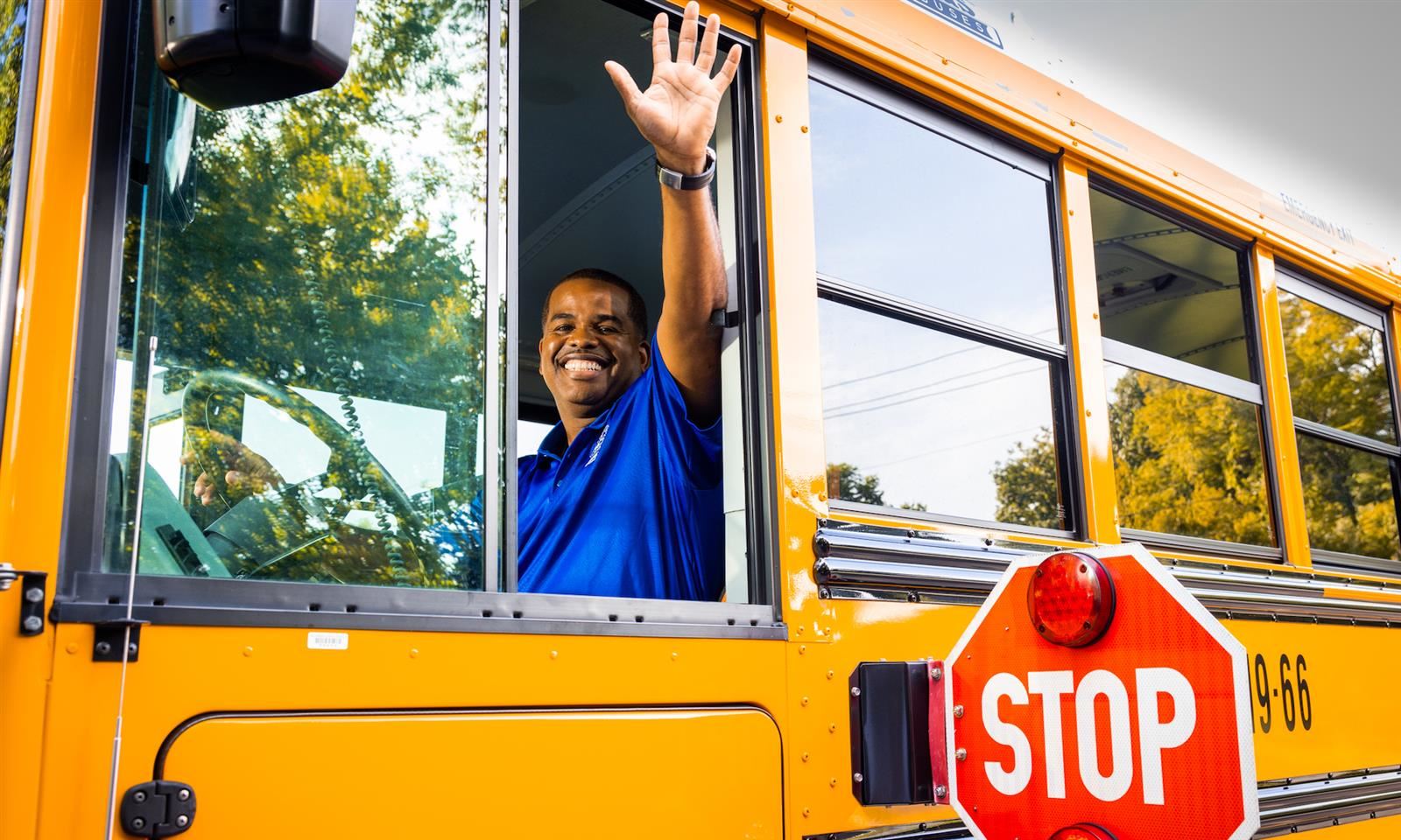 A bus driver waves